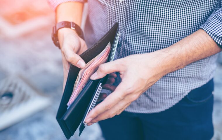 Man,Standing,Holding,Black,Wallet,Full,Of,Money